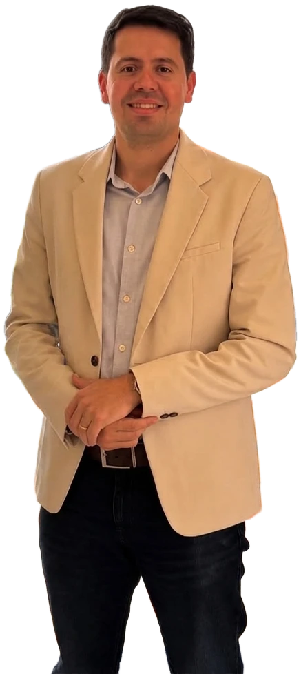 Dr. Caio Blanch de pé, de blazer bege e camisa clara, com as mãos juntas, olhando para quem vê